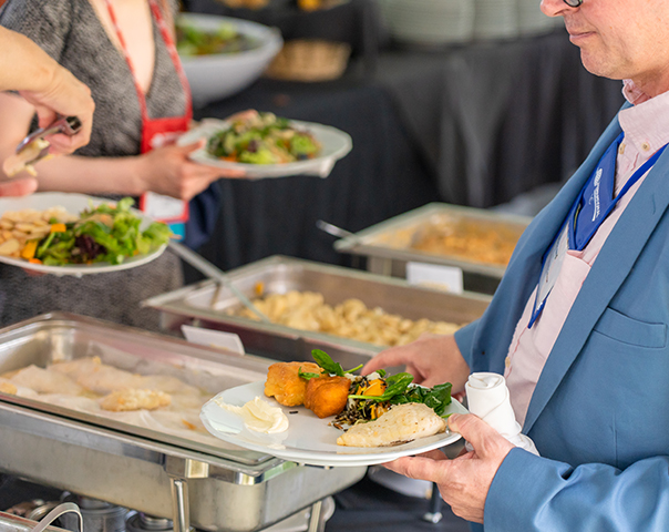 Event guests filling plates from buffet-style catering