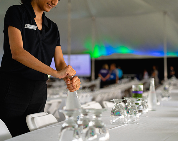 Catering staff pouring beverage for banquet style event