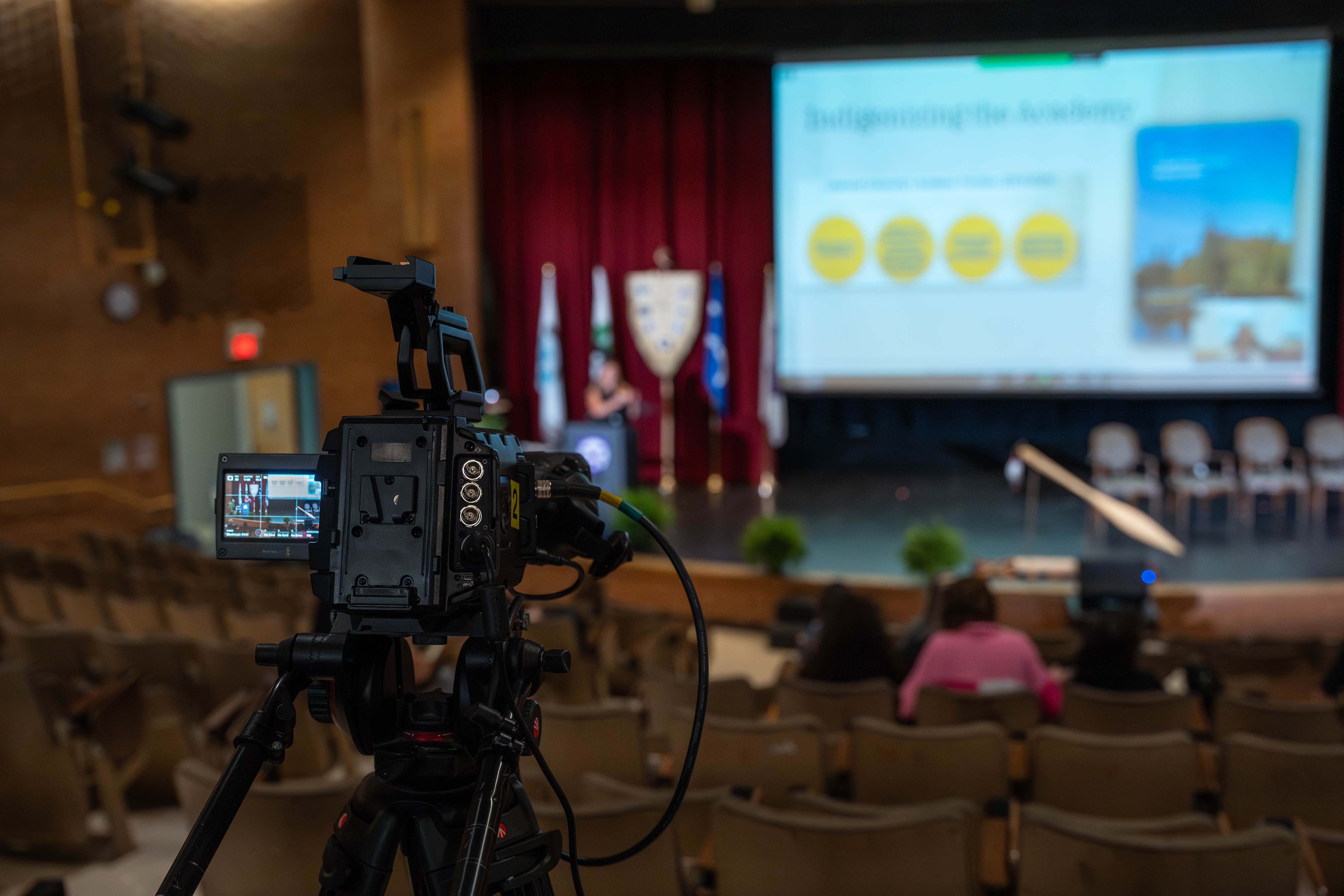 A video camera recording an event on stage